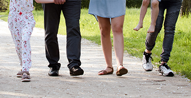 Gruppe von Menschen laufen auf einem Weg mit Schuhen mit orthopädischen Einlagen vom Sanitätshaus Caroli.